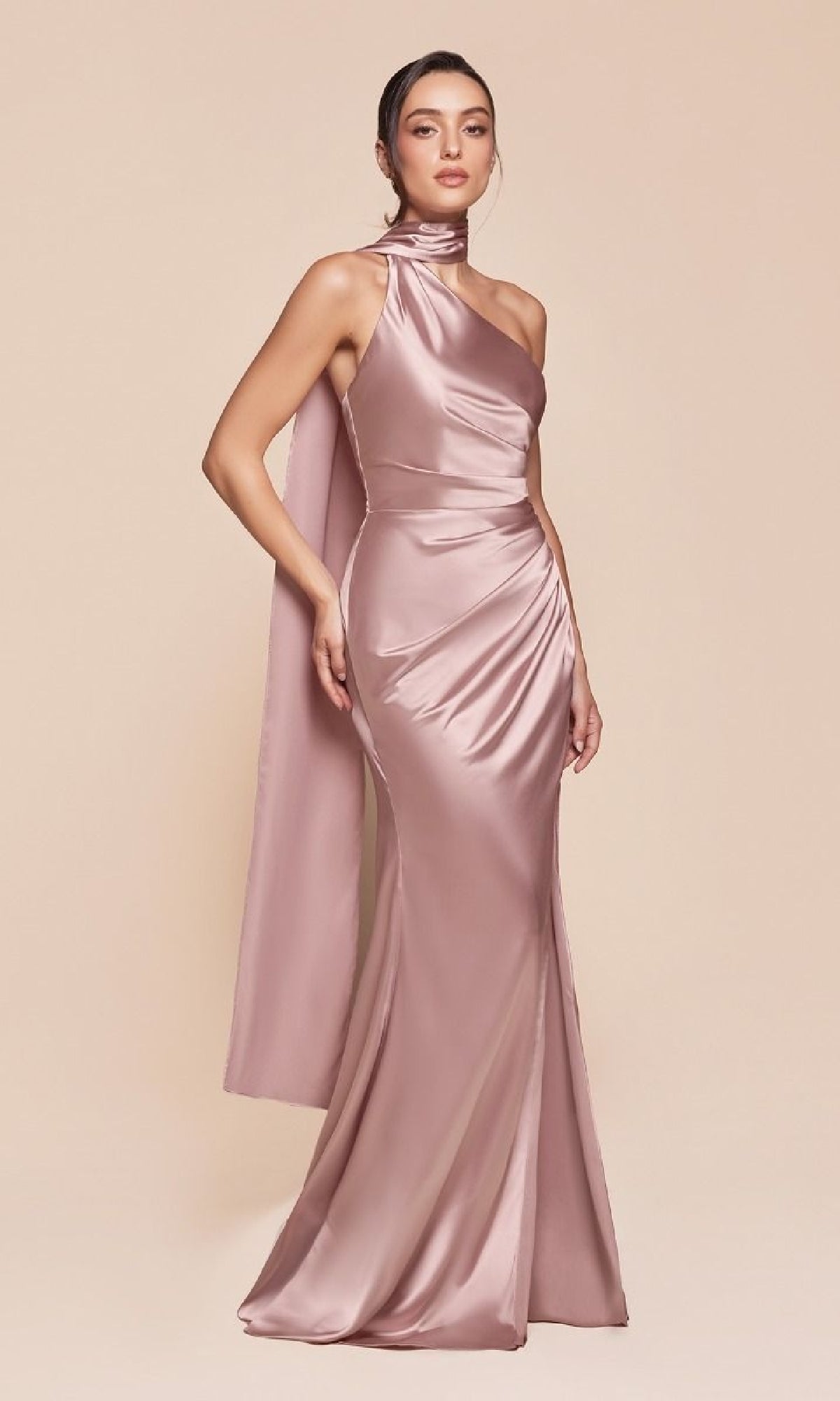A woman poses against a plain beige background, wearing the One-Shoulder Sash Long Prom Dress (Ladivine 7454), a floor-length satin gown featuring a one-shoulder design and elegant draped detailing.